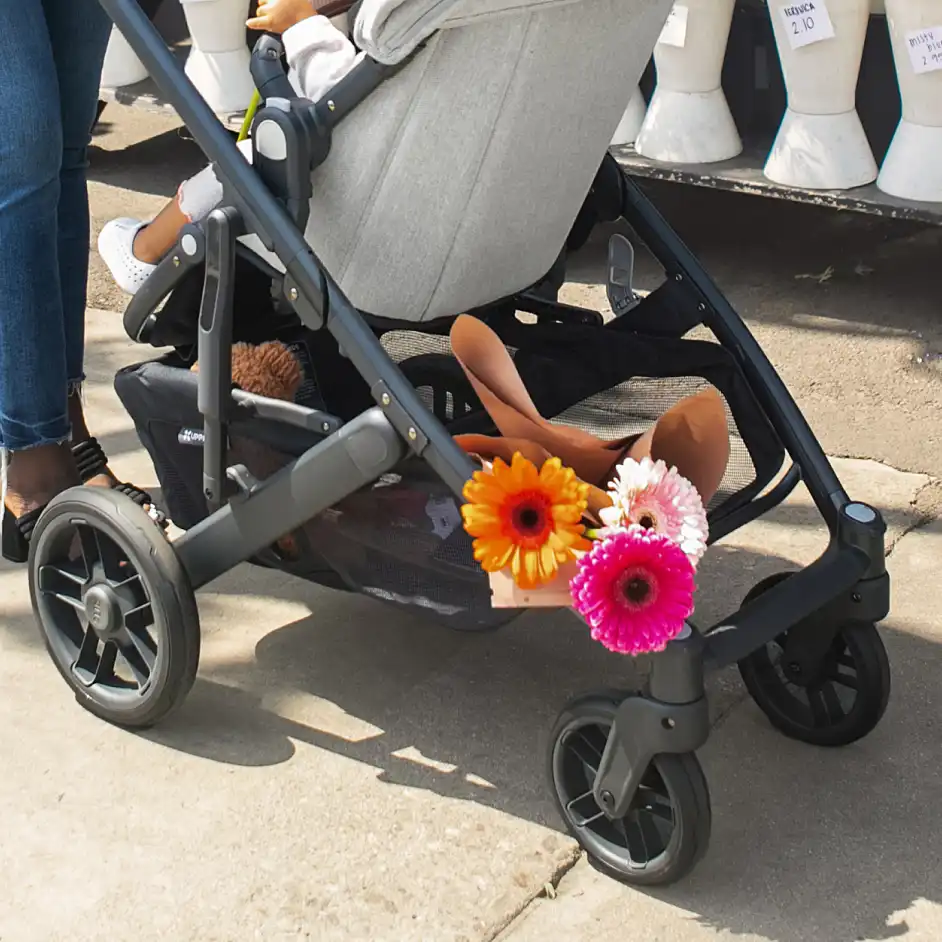 Parent strolling with young child in parent facing toddler seat on Cruz V2 featuring a large basket that can hold up to 30 lbs