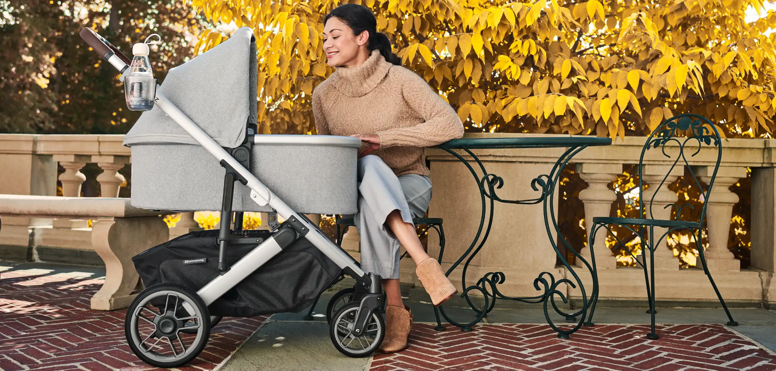 A woman smiles at her child in the Bassinet accessory, that when added to the Cruz V2, the pram can be used as a newborn solution