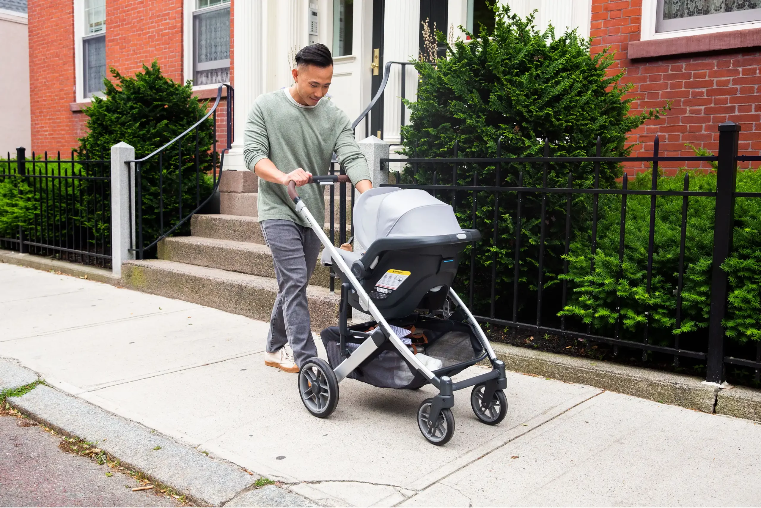A caring man tends to his child in the Mesa V2 carrier attached directly to the Cruz stroller (no adapters needed), easily allowing him to go from drive to stroll