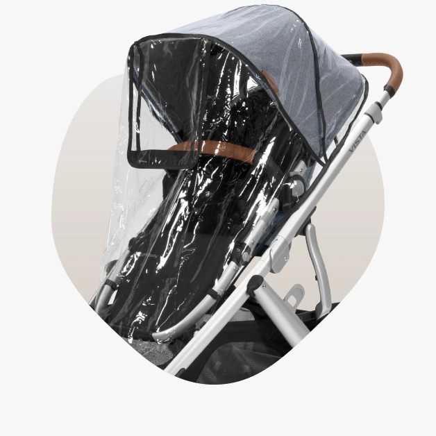Vista V2 stroller (Gregory - blue mélange, silver frame, saddle leather) with its included rain shield attached to the UPF 50+ canopy