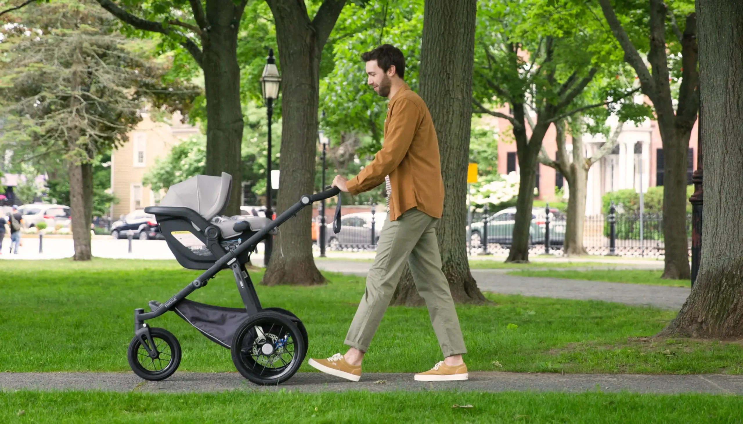 Parent pushing Ridge Stroller with Mesa Car Seat attached using Adapters