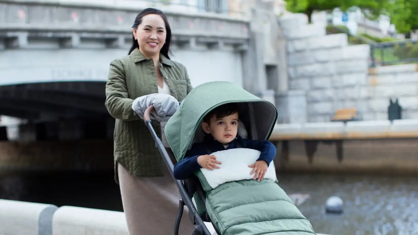 Parent pushing child in forward facing Toddler Seat on stroller with CozyHandmuffs in Stella