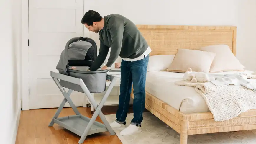 Parent checking on on infant in Bassinet resting on Bassinet Stand