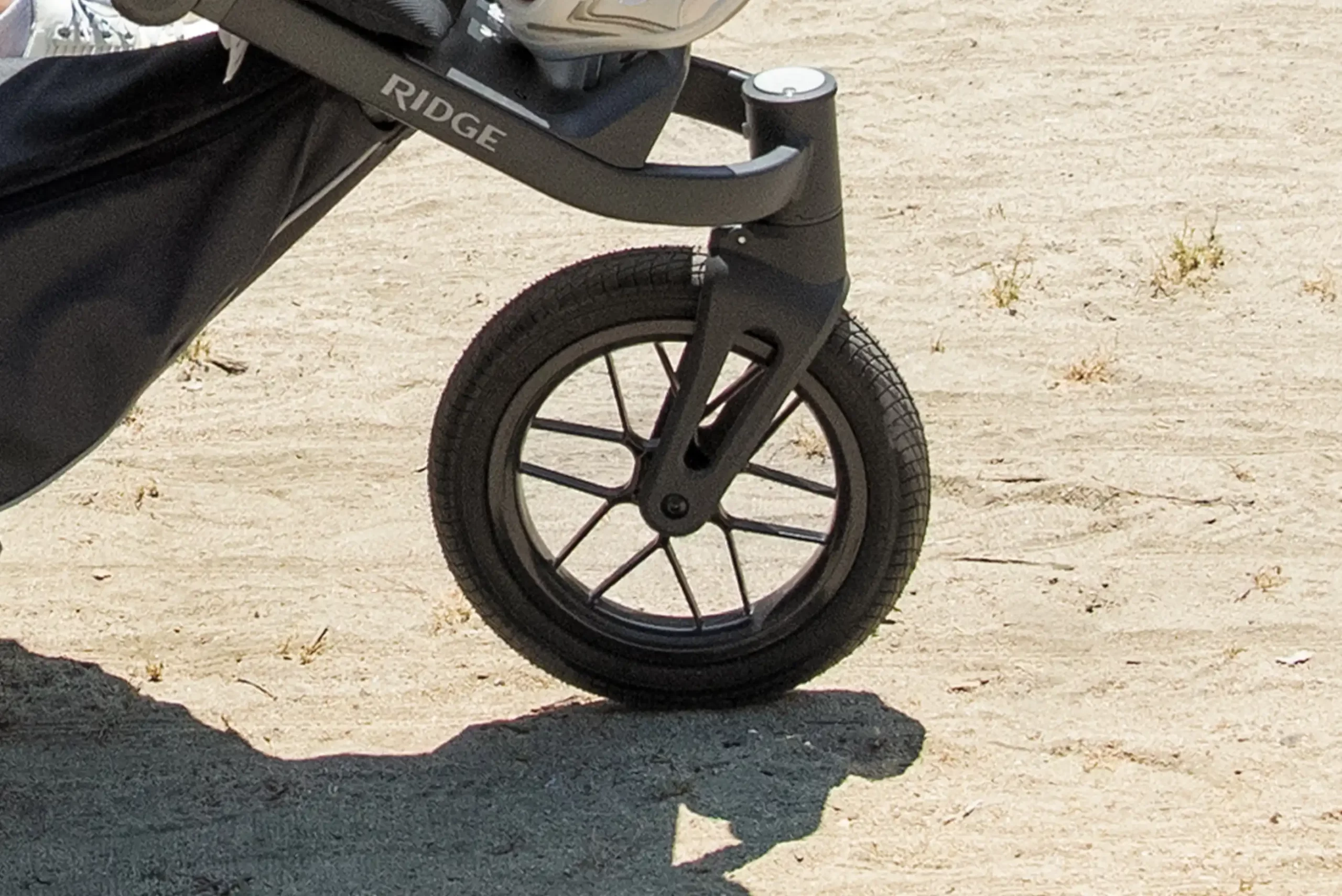 A close up on the Ridge's swivel-locking front wheel, which is one of the three deep tread wheels on the stroller that do not require inflation