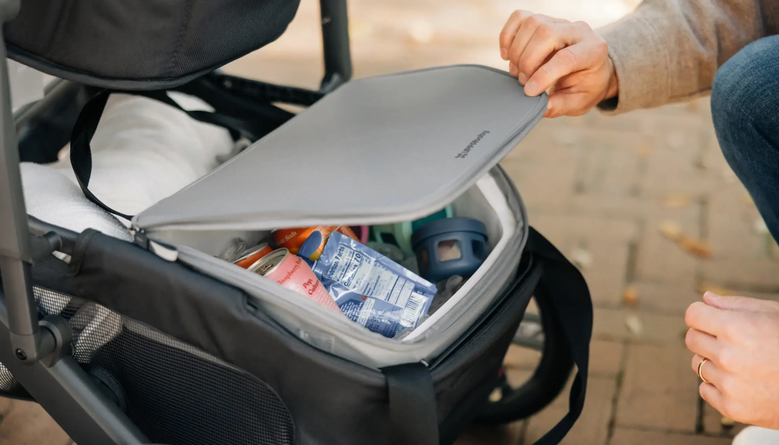 Parent opening Bevvy™ cooler inside Stroller basket