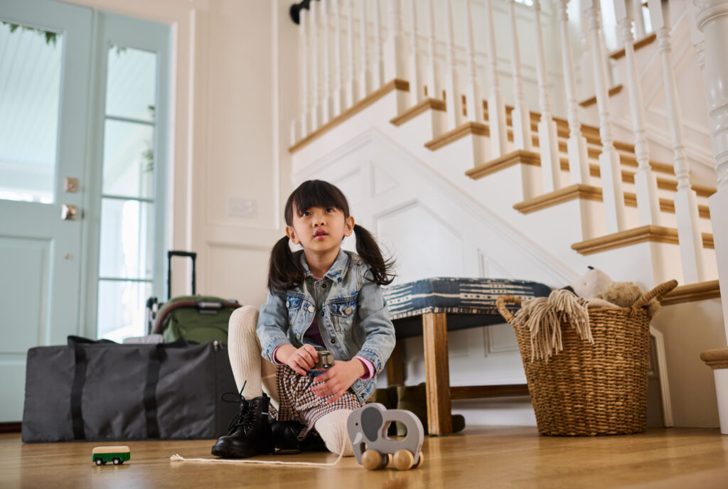 a small child waits for her parents to leave on vacation, with their UPPAbaby products protected with coverage using the UPPAbaby TravelSafe Program