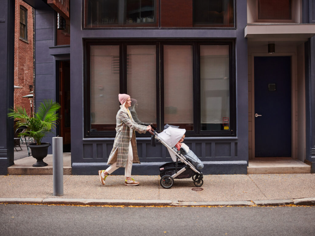 A woman pushing her child in an UPPAbaby Cruz V2 Stroller.