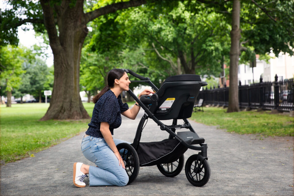 A parent finds comfort and ease using their UPPAbaby Ridge stroller in the park.