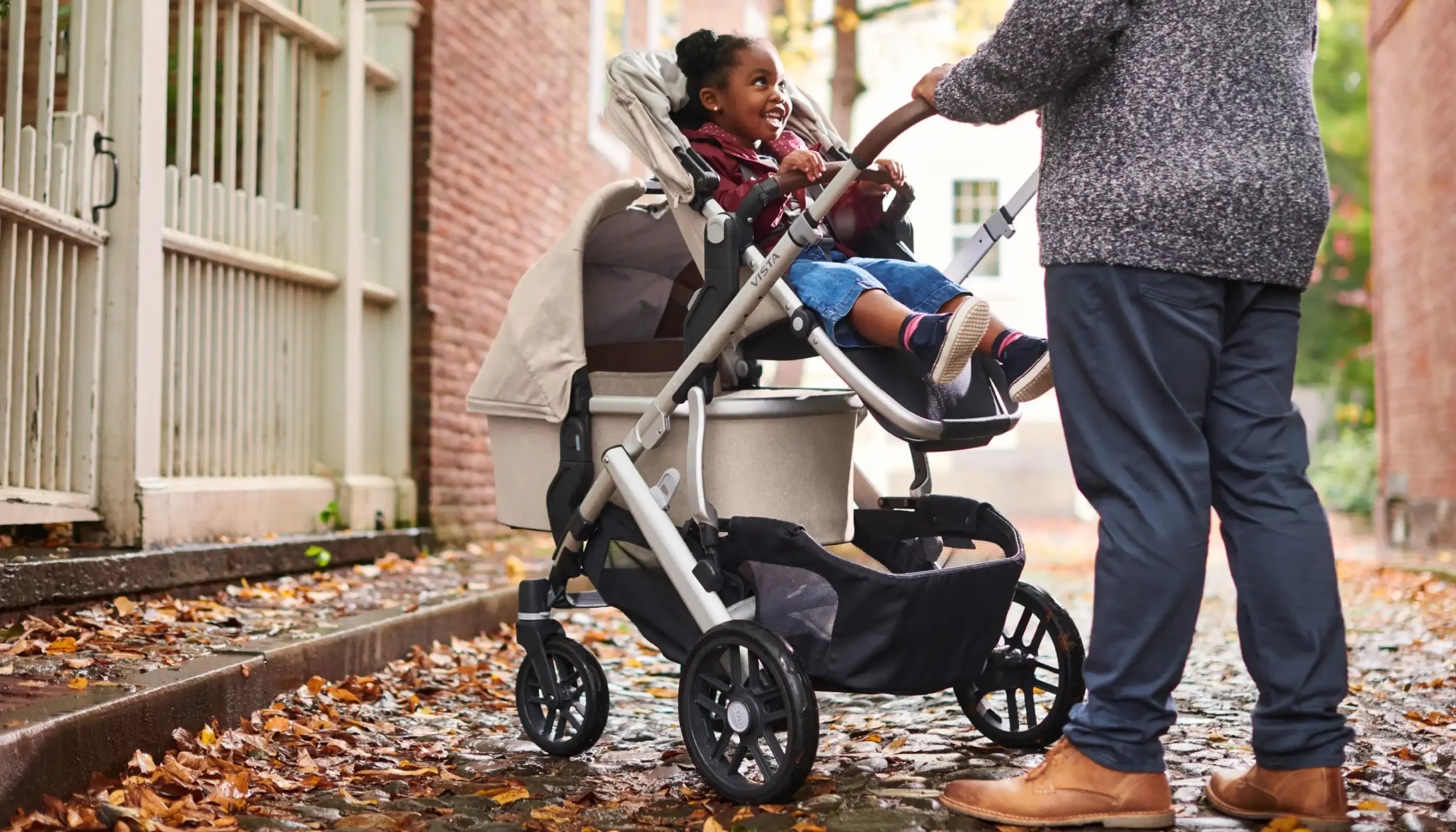 Parent pushing Vista Stroller with Toddler Seat and Bassinet using Lower Adapters