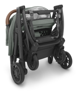Compact UPPAbaby Minu V2 stroller in Gwen Green Mélange with a convenient carry strap for easy transportation