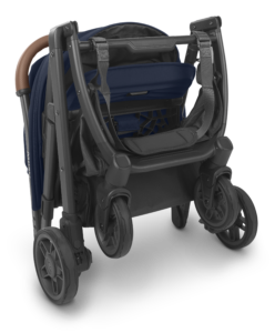 Elegantly folded UPPAbaby Minu V2 stroller in Noa Navy, featuring a handy carry strap for portability