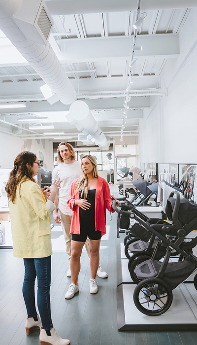 UPPAbaby Hub Staff Member showing a man and woman around the Showroom at a Hub location