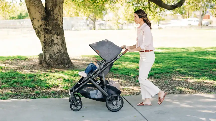 Mom smiles while strolling with her young child in Vista V3 toddler seat with extended sun shade