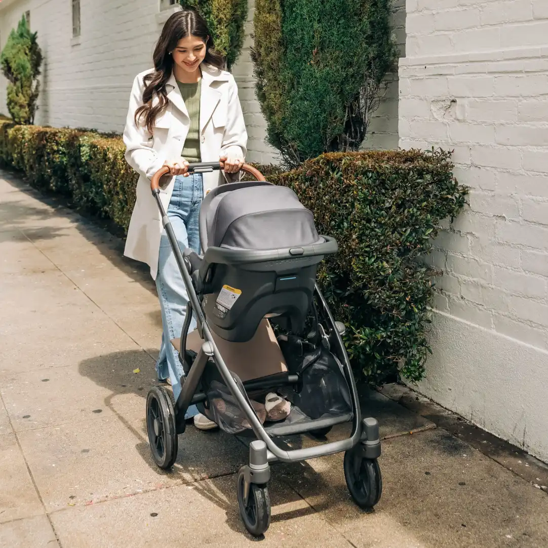 Mom smiles while strolling with baby in Mesa infant car seat with direct attachment to Vista V3