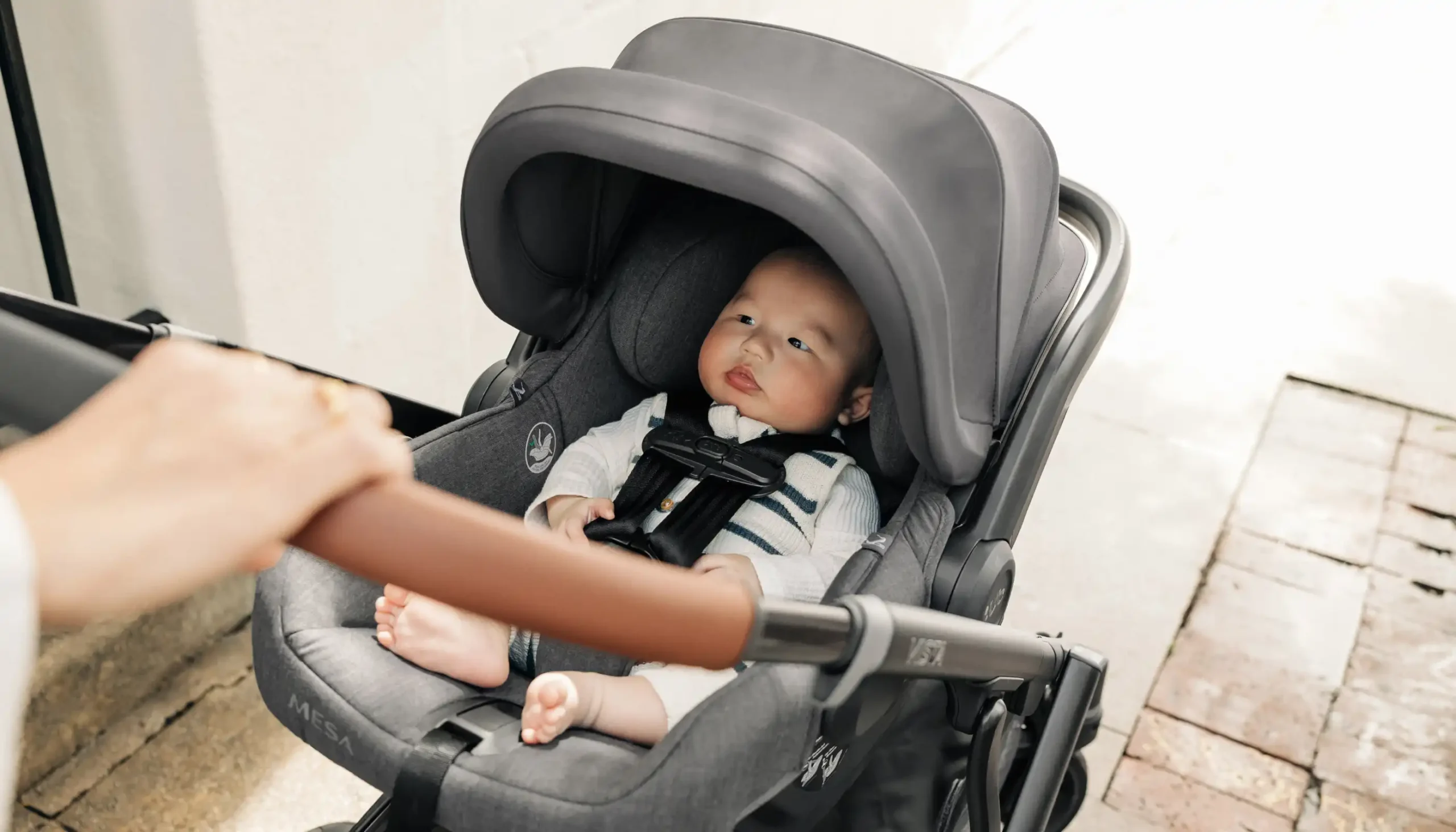 Parent strolling with child in Mesa V2 car seat directly attached to Vista V3 stroller