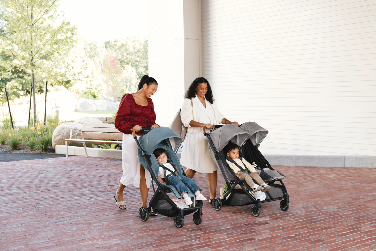 Parents push their children on an urban sidewalk in Minu V3 and Minu Duo strollers