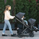 Parent walks with a Vista V3 that has a RumbleSeat V3 and Toddler Seat with Upper adapters