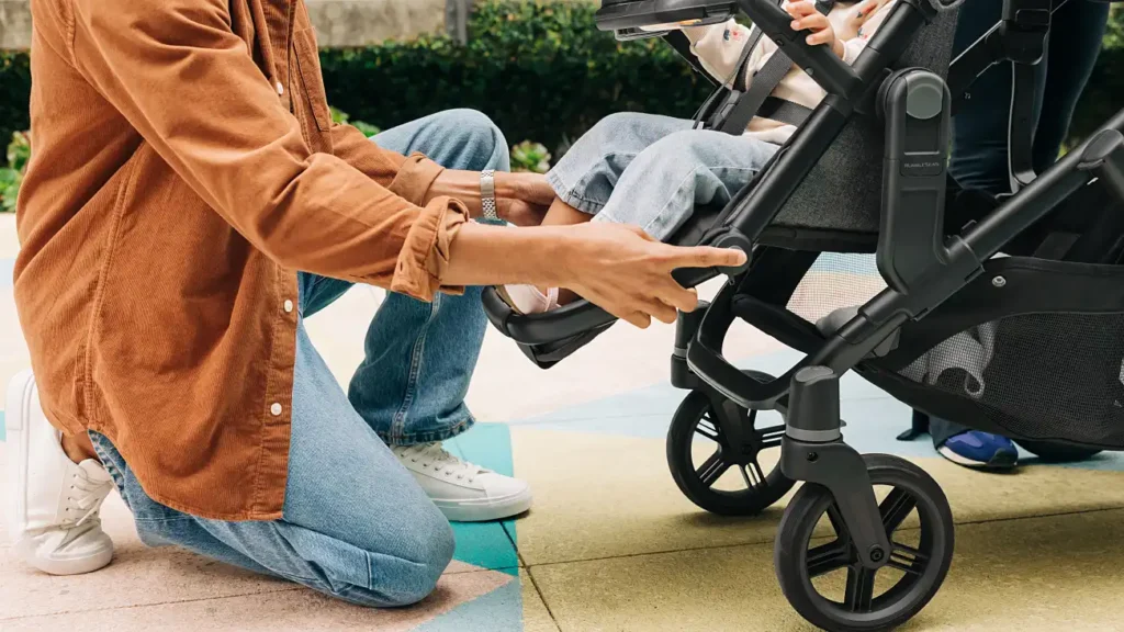 A parent adjusts the footrest for the child sitting in the RumbleSeat